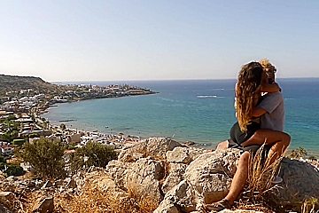 Beautiful teen 18+ Couple In Love Passionately Kissing Above The Sea On Crete Island