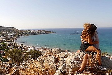 Beautiful teen 18+ Couple In Love Passionately Kissing Above The Sea On Crete Island