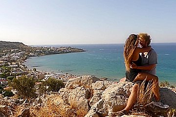 Beautiful teen 18+ Couple In Love Passionately Kissing Above The Sea On Crete Island