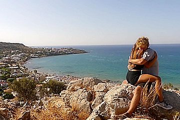 Beautiful teen 18+ Couple In Love Passionately Kissing Above The Sea On Crete Island
