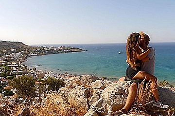 Beautiful teen 18+ Couple In Love Passionately Kissing Above The Sea On Crete Island