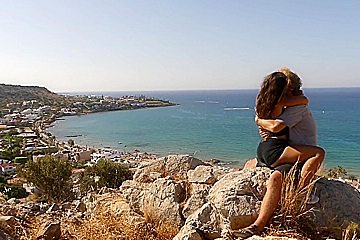 Beautiful teen 18+ Couple In Love Passionately Kissing Above The Sea On Crete Island