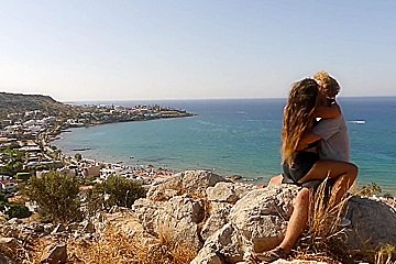 Beautiful teen 18+ Couple In Love Passionately Kissing Above The Sea On Crete Island