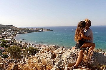 Beautiful teen 18+ Couple In Love Passionately Kissing Above The Sea On Crete Island