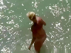 Blonde nude woman in the beach