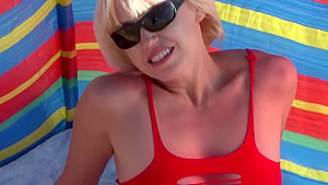 Blonde plays with her pussy on a nudist beach