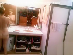 Busty blonde brushes her hair and takes a shower
