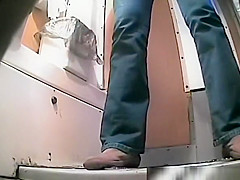 Woman in jeans peeing in toilet