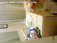 blonde coed throws things at the camera while trying to pee