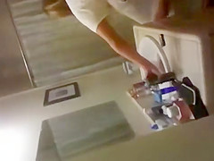 blonde coed throws things at the camera while trying to pee